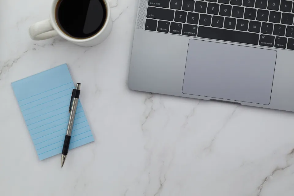Workspace with laptop, notepad and coffee